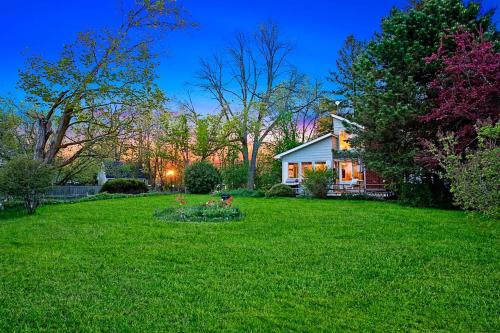 a house in a yard with a green lawn at PRIVATE COTTAGE GETAWAY On LAKE SIMCOE in Brechin