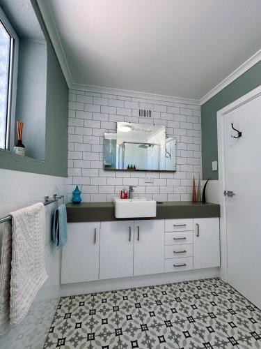 a bathroom with a sink and a mirror at Cottage Bliss on Moonta Main St in Moonta