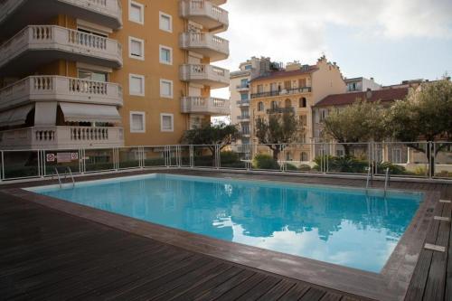 une grande piscine devant un immeuble dans l'établissement SUPER STUDIO AVEC PISCINE À 60 m DE LA MER, à Nice