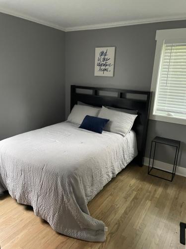 a bedroom with a bed with a blue pillow on it at Freshly Remodeled Cozy 3 Bedroom Home in Des Plaines