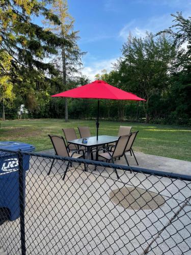 a table with chairs and a red umbrella at Freshly Remodeled Cozy 3 Bedroom Home in Des Plaines