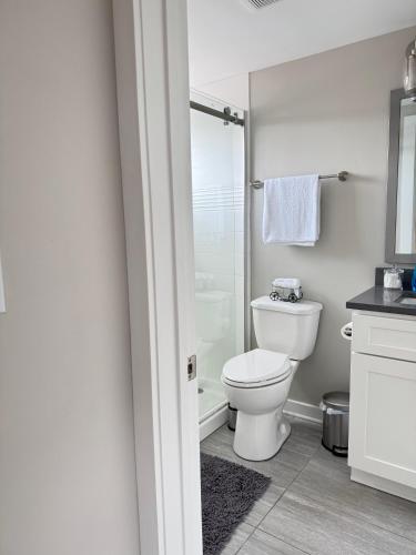 a white bathroom with a toilet and a shower at Horizon Hideaway in Mobile