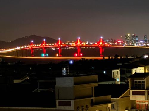 a view of a bridge at night with red lights at 筑月馆民宿 in Jinning
