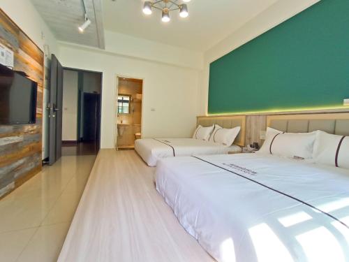 a bedroom with two beds and a green wall at 筑月馆民宿 in Jinning