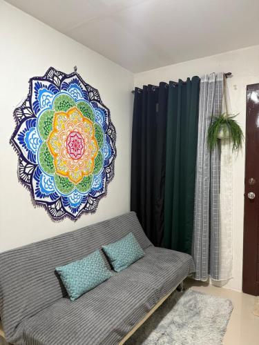 a couch in a living room with a mandala on the wall at RiDivingSpot Mabini in Mabini