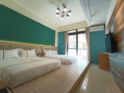 a bedroom with two beds and a flat screen tv at 筑月馆民宿 in Jinning