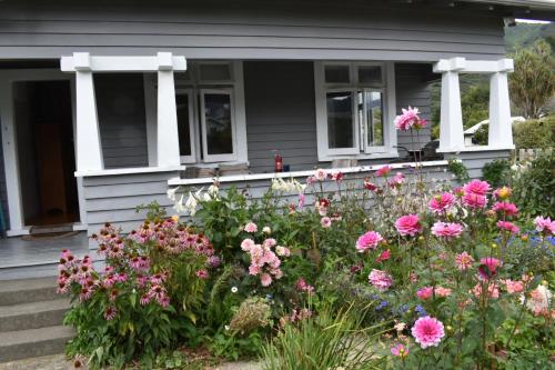 a house with a bunch of flowers in front of it at Te Hoiere Guesthouse in Havelock