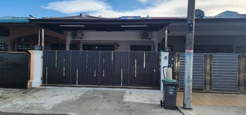 a fence in front of a house with a parking meter at 4 bedroom homestay @ Mersing in Mersing