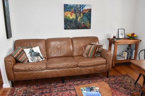 a brown leather couch in a living room at Te Hoiere Guesthouse in Havelock