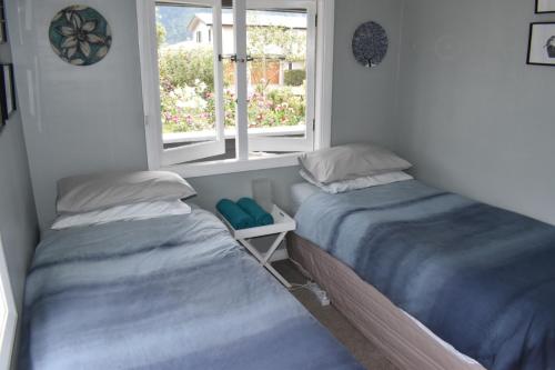a bedroom with two beds and a window at Te Hoiere Guesthouse in Havelock