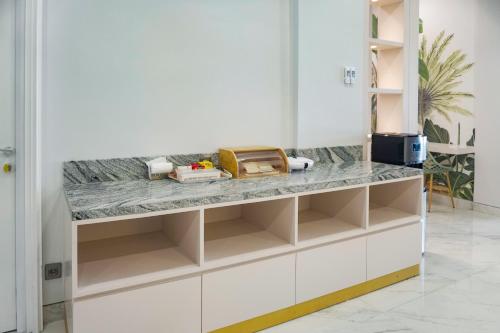 a kitchen with white cabinets and marble counter tops at Urbanview Kencana Residence near Pakuwon Mall Surabaya in Ngemplak 2