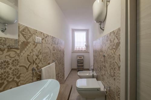 a bathroom with a tub and a toilet and a sink at 10min Da Bosa Marina - Con Giardino e Parcheggio in Tresnuraghes