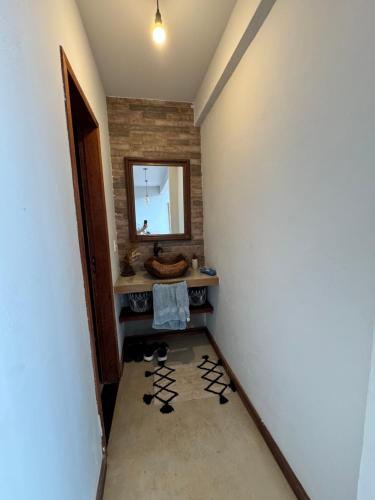 a hallway with a mirror and shoes in a room at Chalé Alto do Valle in Paty do Alferes