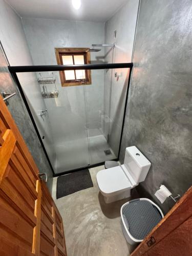 a small bathroom with a toilet and a shower at Chalé Alto do Valle in Paty do Alferes