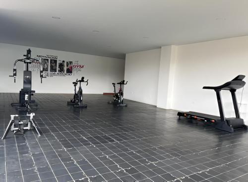 a gym with three exercise bikes in a room at El Castillo de los Reyes in Curití