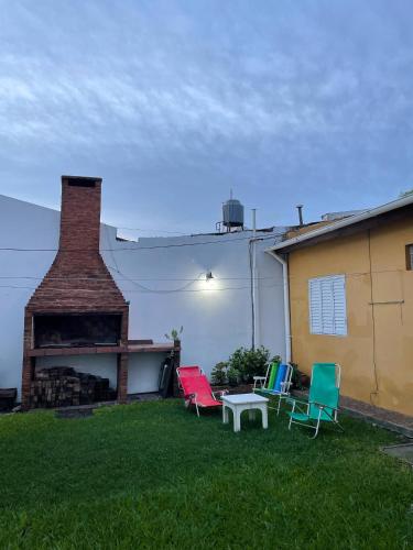 a group of chairs sitting in the grass next to a building at Santa Teresita in Concepción del Uruguay
