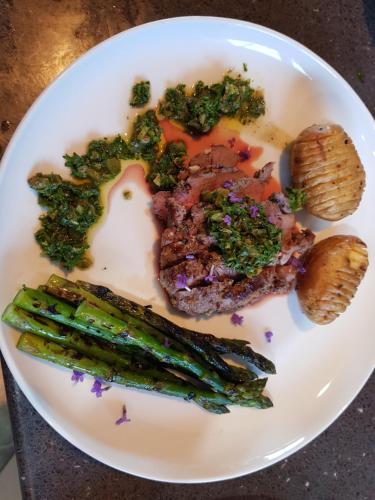a plate of food with meat broccoli and asparagus at Te Hoiere Guesthouse in Havelock
