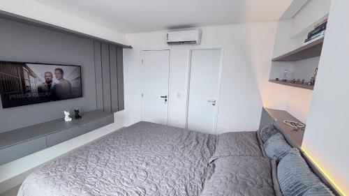 a bedroom with a bed and a tv on a wall at Quarto São João - familiar in Campina Grande