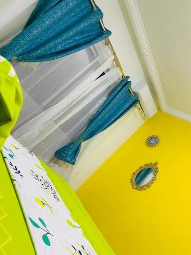 a bedroom with a window with a blue curtain at Khurtis 225 in Abidjan