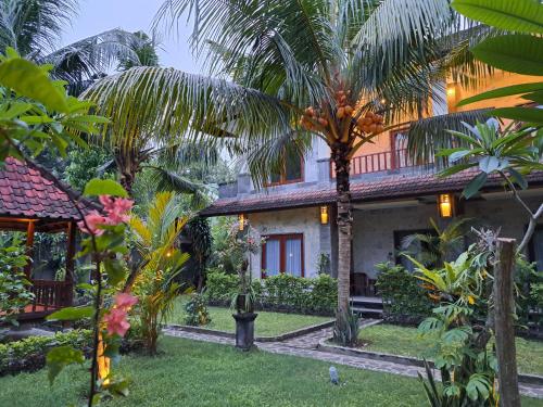 a house with palm trees in front of it at Asli Bali, the real Bali in Candidasa