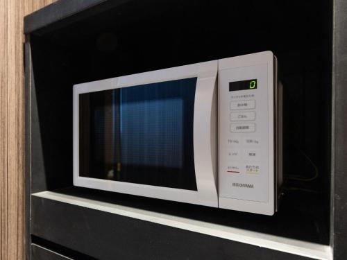 a microwave oven sitting on top of a shelf at APA Hotel Suidobashi Ekimae in Tokyo