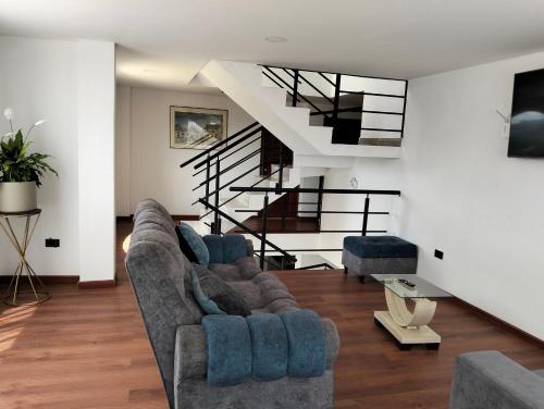 a living room with two couches and a staircase at Villa Graciela II in Paipa