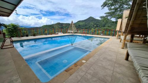 a swimming pool with a mountain in the background at New Paradise Nueva Sede - La Vega Cundinamarca in Villeta