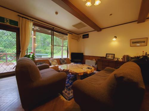a living room with a couch and a table at Pension J-HOUSE in Kiso