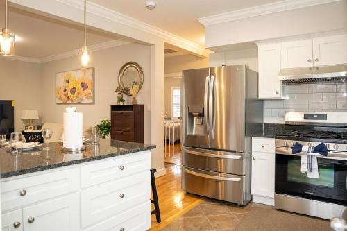 a kitchen with white cabinets and a stainless steel refrigerator at 40-Newly renovated, stylish and beautiful apartment with 4br in Boston
