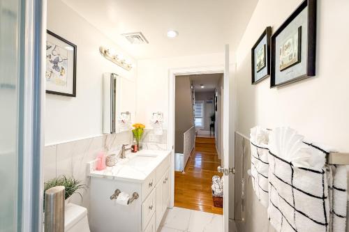 a white bathroom with a sink and a mirror at 40-Newly renovated, stylish and beautiful apartment with 4br in Boston