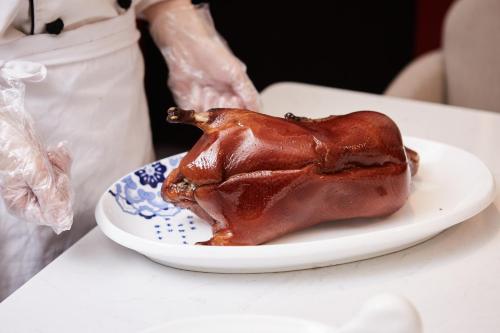 a cooked turkey on a plate on a table at THE YARD HOTEL BEIJING,BianyiFang - steps The Forbidden City - strolling through the imperial gardens is incredibly easy - The guest rooms blend modern comfort with Chinese charm - Peking duck - living in history Your Beijing adventure begins here in Beijing
