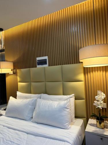 a bedroom with a large bed with white pillows at Perc Hotel in Pinamungahan