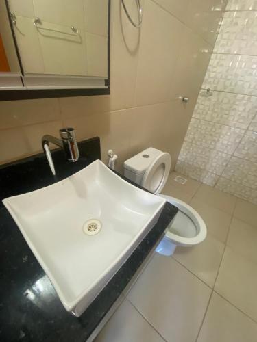 a bathroom with a white sink and a toilet at Ap no campo dos velhos com ar in Sobral