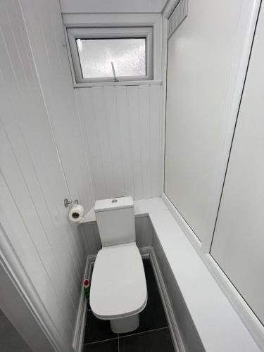a small bathroom with a toilet and a window at Luxury 2 bed house and Pool table in Harborne in Birmingham
