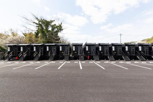 a row of black containers in a parking lot at HOTEL R9 The Yard Kanzaki in Kanzaki