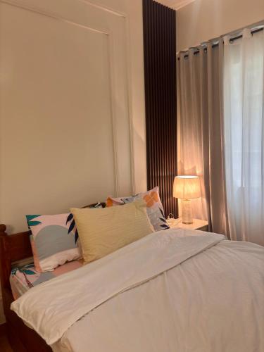 a bedroom with a white bed with a window at Cozy Near Mall SM Fairview Trees Residences Quezon City in Manila