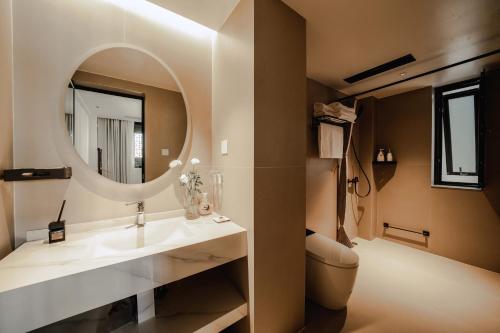a bathroom with a sink and a mirror at Dali Wenshuo Ancient City Center Private Courtyard Hotel in Dali Ancient Town