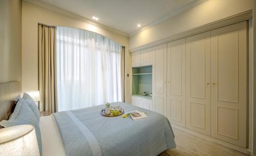a bedroom with a bed with a bowl of fruit on it at Green Court Residence City Center, Shanghai in Shanghai