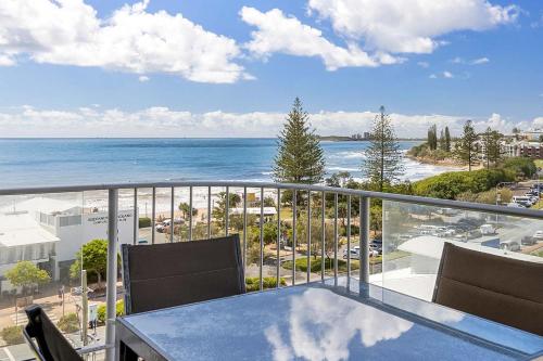 a balcony with a table and chairs and the ocean at Mandolin Beachfront Resort in Alexandra Headland