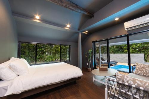 a bedroom with a bed and a large window at Tida Sesoko in Motobu