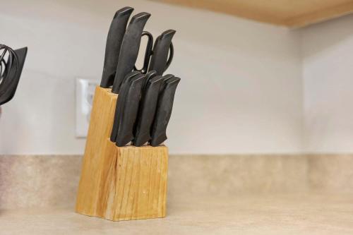a wooden block of knives sitting on top of a counter at Spacious 2BR Retreat with Pool Access - Barefoot in North Myrtle Beach