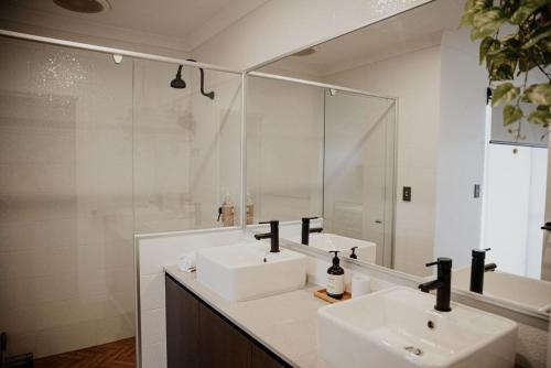 a bathroom with two sinks and a mirror at Mojo's Lodge in Margaret River Town