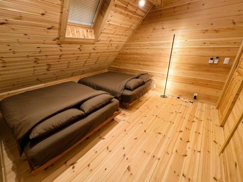 a room with two beds in a log cabin at P's Wood 伊豆高原 in Ito