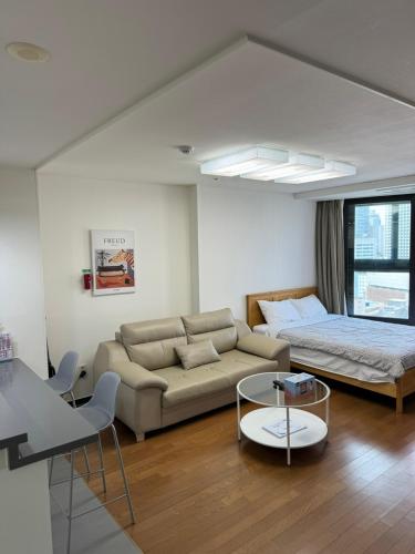 a living room with a couch and a bed at Haeundae Beach Stay Hotel in Busan
