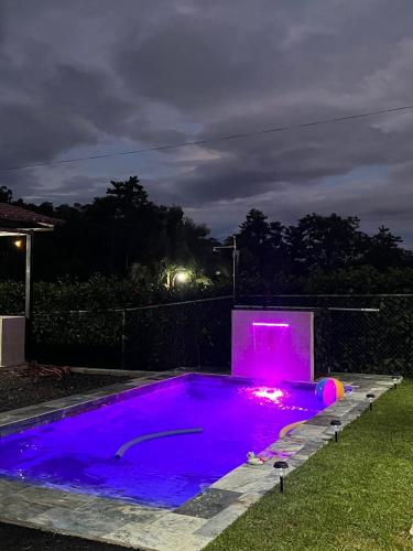 a swimming pool lit up purple at night at Quinta La Esperanza in Chachagua