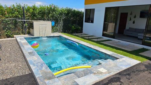 a swimming pool with a ball in a yard at Quinta La Esperanza in Chachagua