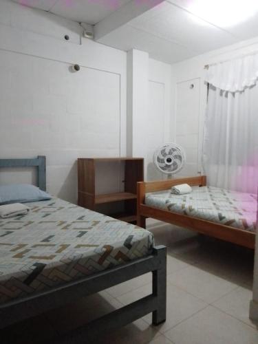 a bedroom with two beds and a window at Casa Hostal Arena de Mar in Necoclí