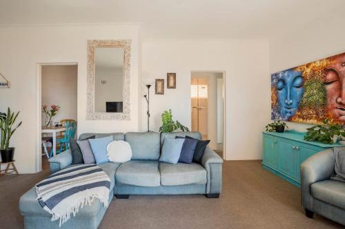 a living room with a couch and a painting on the wall at Beachside Oasis - Ocean Views and Walk to Everything in Wollongong