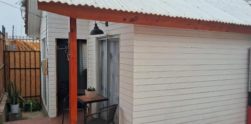 a white building with awning and a table on a patio at La Casita en Caldera in Caldera