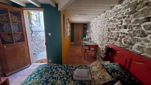 a room with a bed and a stone wall at La Concha 1 in Conques-sur-Orbiel